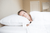 A woman sleeping in a bed with a white Pillowtex Triple Core Lyocell Pillow | Medium Support.